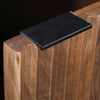 Macro shot focusing on the sleek black metal tab handle integrated into the top of the ribbed door panel