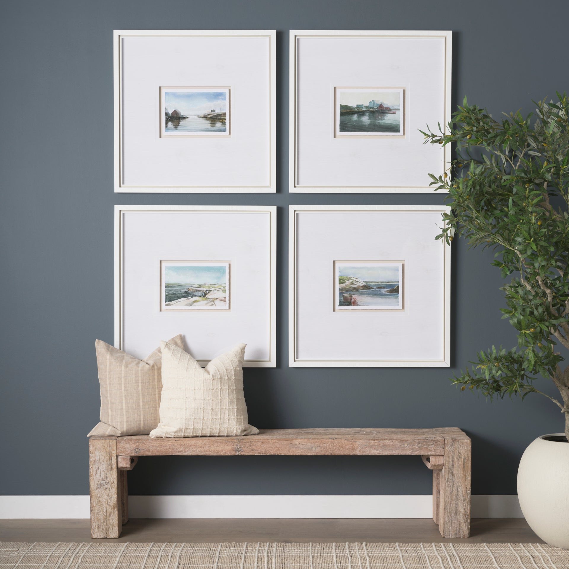 Lifestyle shot featuring the console used as a bench in a minimalist hallway styled with a gallery wall and neutral pillows