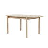 Three-quarter perspective view highlighting the clean architectural lines and the warm natural wood grain of the Runway dining table
