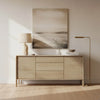 Moody lifestyle shot featuring the sideboard styled with a warm table lamp and abstract art in a contemporary interior