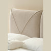 Close-up lifestyle shot of the headboard styled with white pillows and a soft textured throw blanket