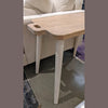 Detailed view of the white-washed tapered legs and smooth wood grain surface