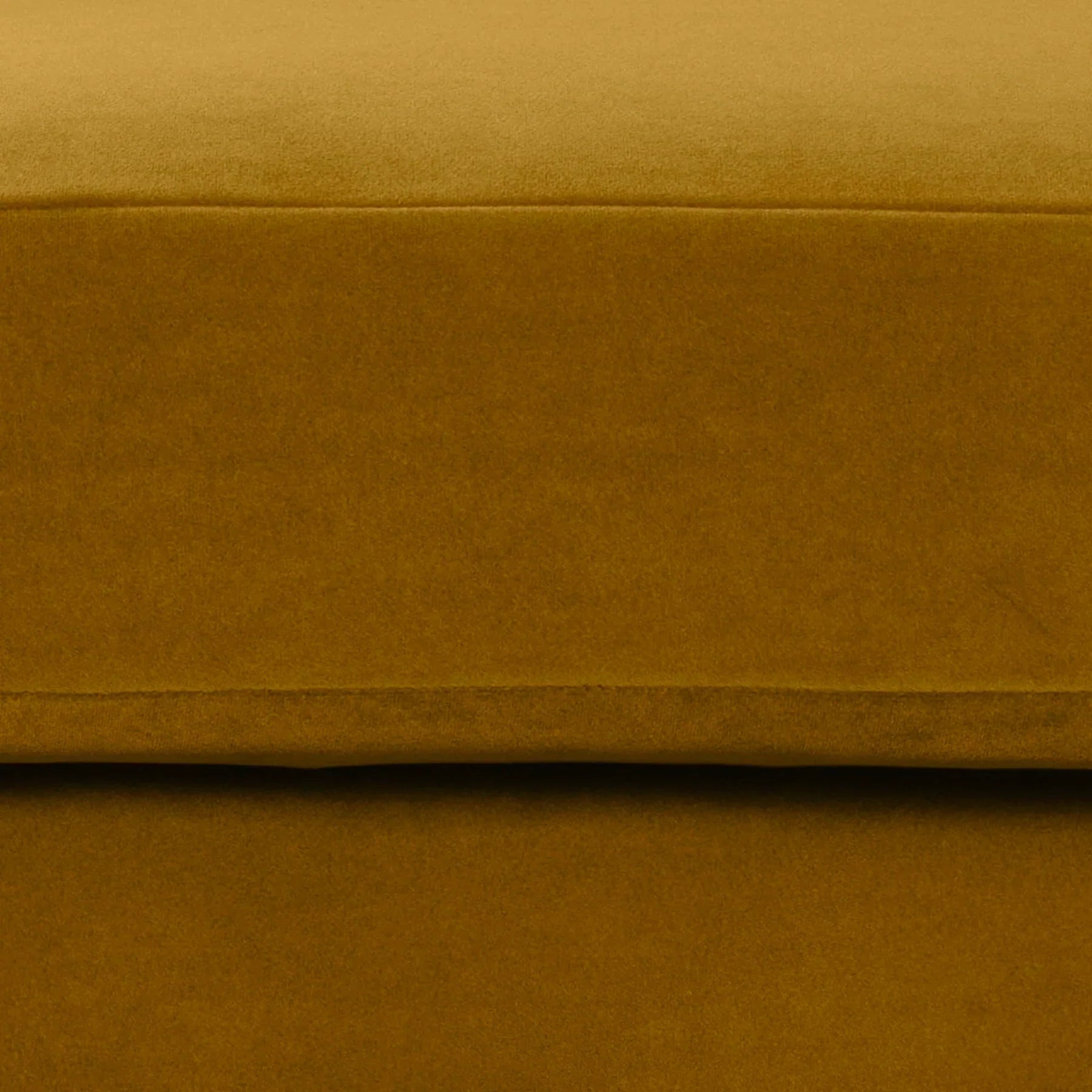 Macro shot of the velvet upholstery demonstrating the soft texture and vibrant mustard color