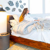 Lifestyle shot featuring the Remix bed styled with neutral bedding in a bright room with a high-angle window
