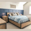 Studio lifestyle shot focusing on the nightstand styled with bedside essentials next to a coordinating wood and metal bed
