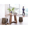 Lifestyle shot featuring the Tanya table in a bright, airy room with a coastal view styled with geometric stools and organic decor
