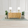 Wide-angle lifestyle shot featuring the Colton sideboard styled with white lamps and greenery in a bright minimalist dining room
