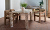 Lifestyle shot featuring the Segment stone table in a modern interior paired with brown upholstered chairs and a minimalist clay vase