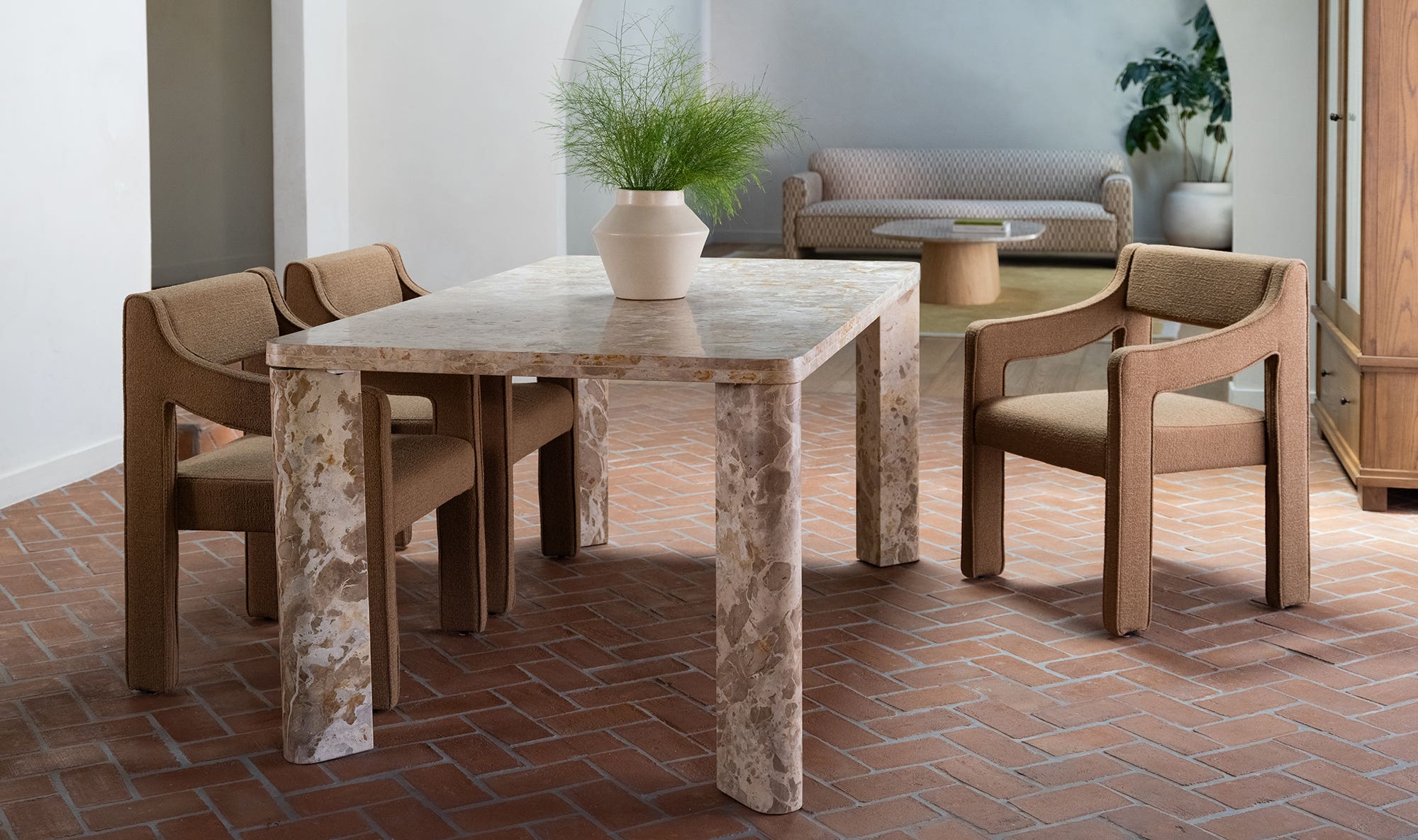 Front view of the Segment dining table in beige panther stone featuring a thick rectangular top and rounded architectural legs