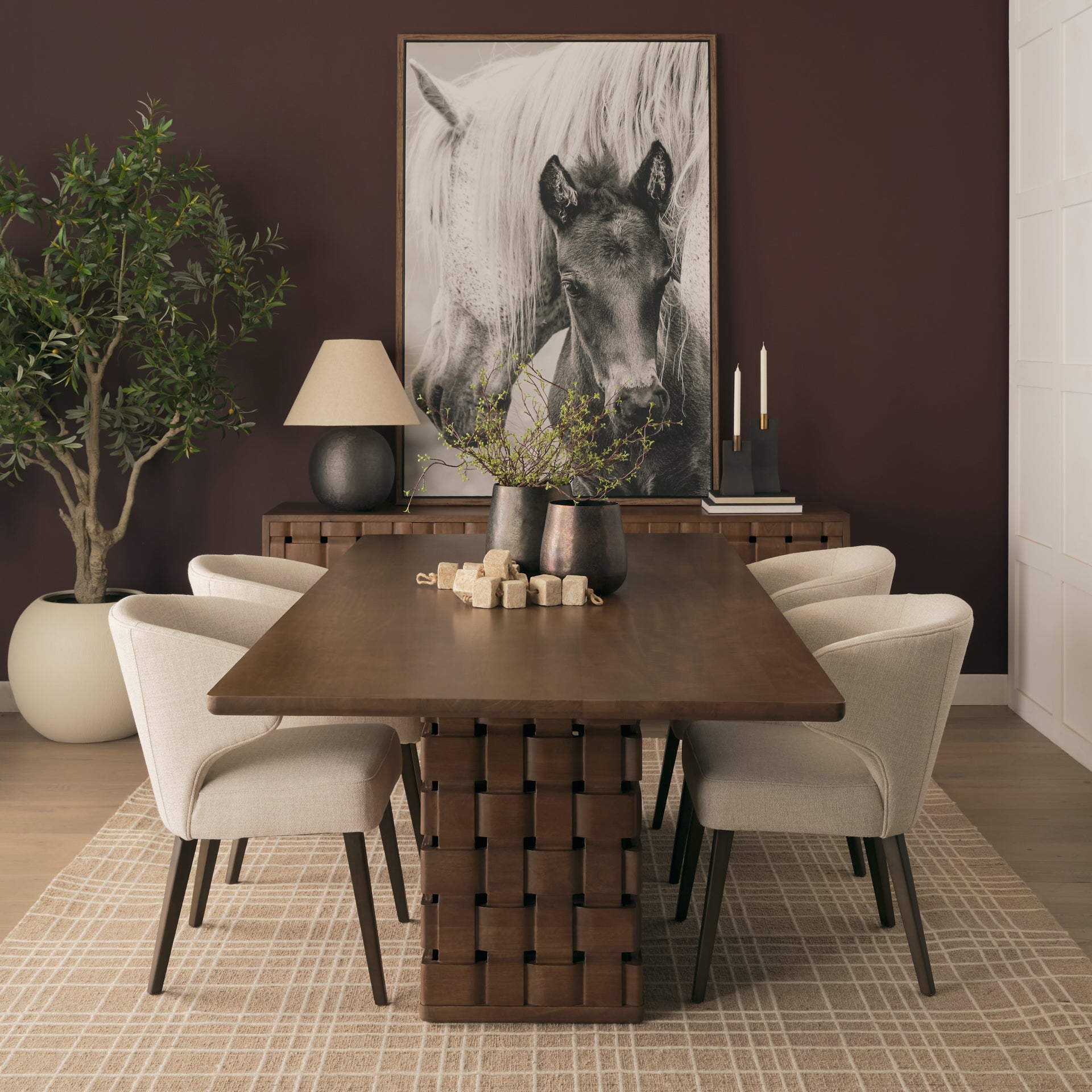 Front view of the 94 inch Trellyn solid wood dining table featuring a thin rectangular top and a decorative carved woven pedestal base