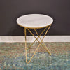 Lifestyle shot of the white marble side table styled on a patterned area rug next to a dark grey wall for a sophisticated modern look