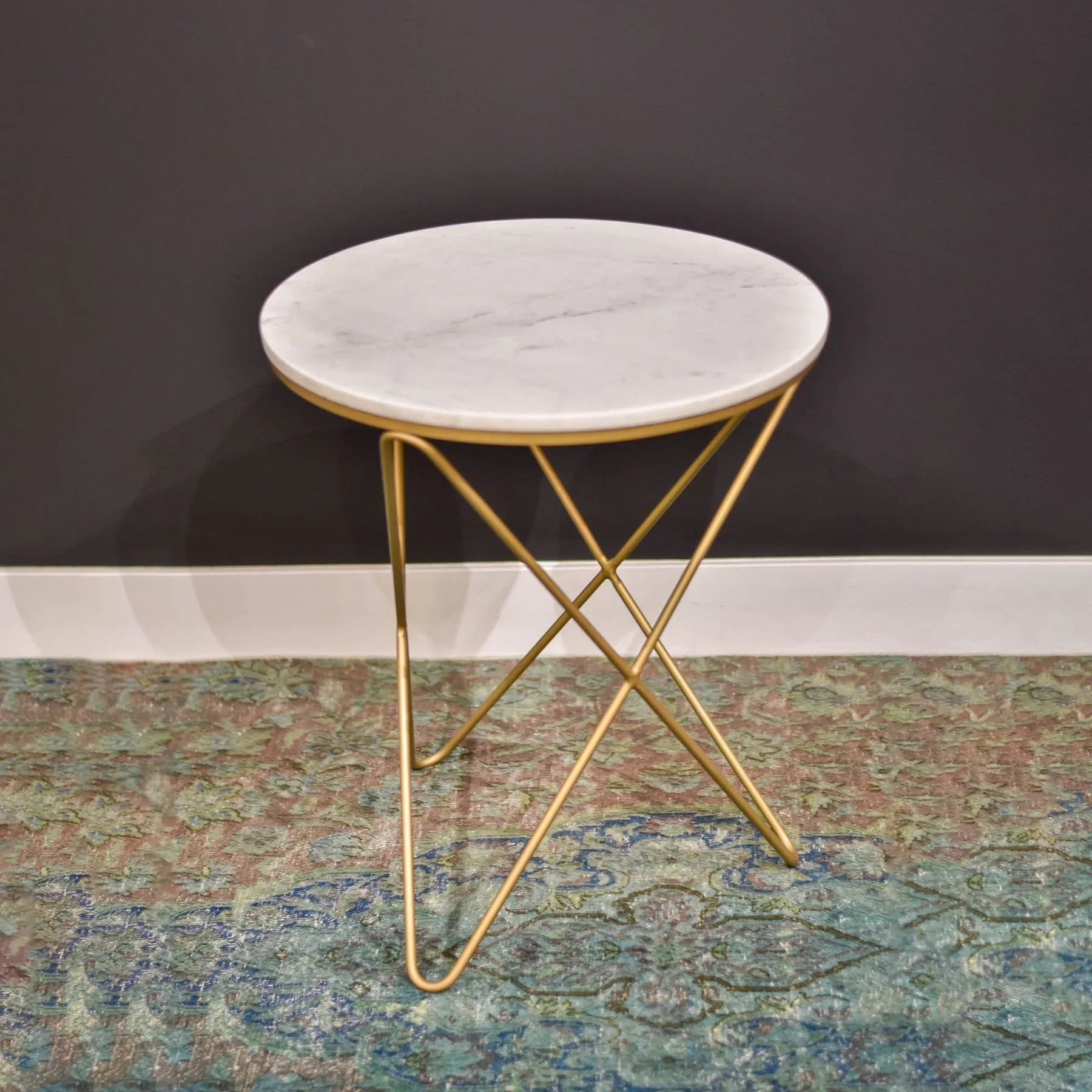 Front view of the Earth Wind and Fire side table featuring a circular white marble top and a sculptural gold-finished geometric wire base