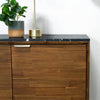 Close-up shot of the contemporary gold-finished linear door handles set against the natural acacia wood grain