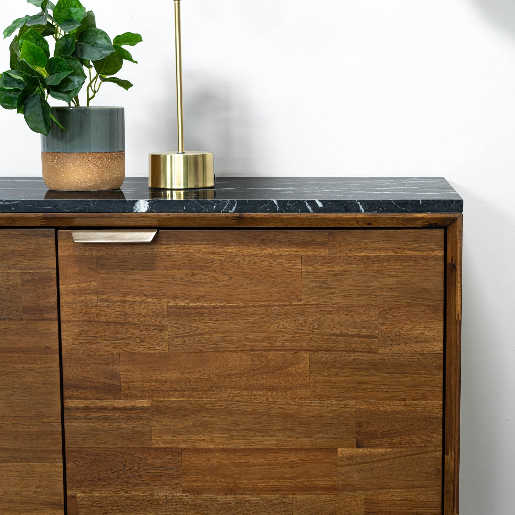 Straight-on front view highlighting the symmetrical wood grain patterns across the three storage doors and the slim gold handles