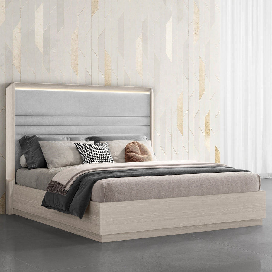 Three-quarter perspective view highlighting the sleek light wood base and the architectural horizontal stitching of the lighted headboard