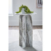 Lifestyle shot of the grey marble pedestal table styled with a small green plant in a bright minimalist interior
