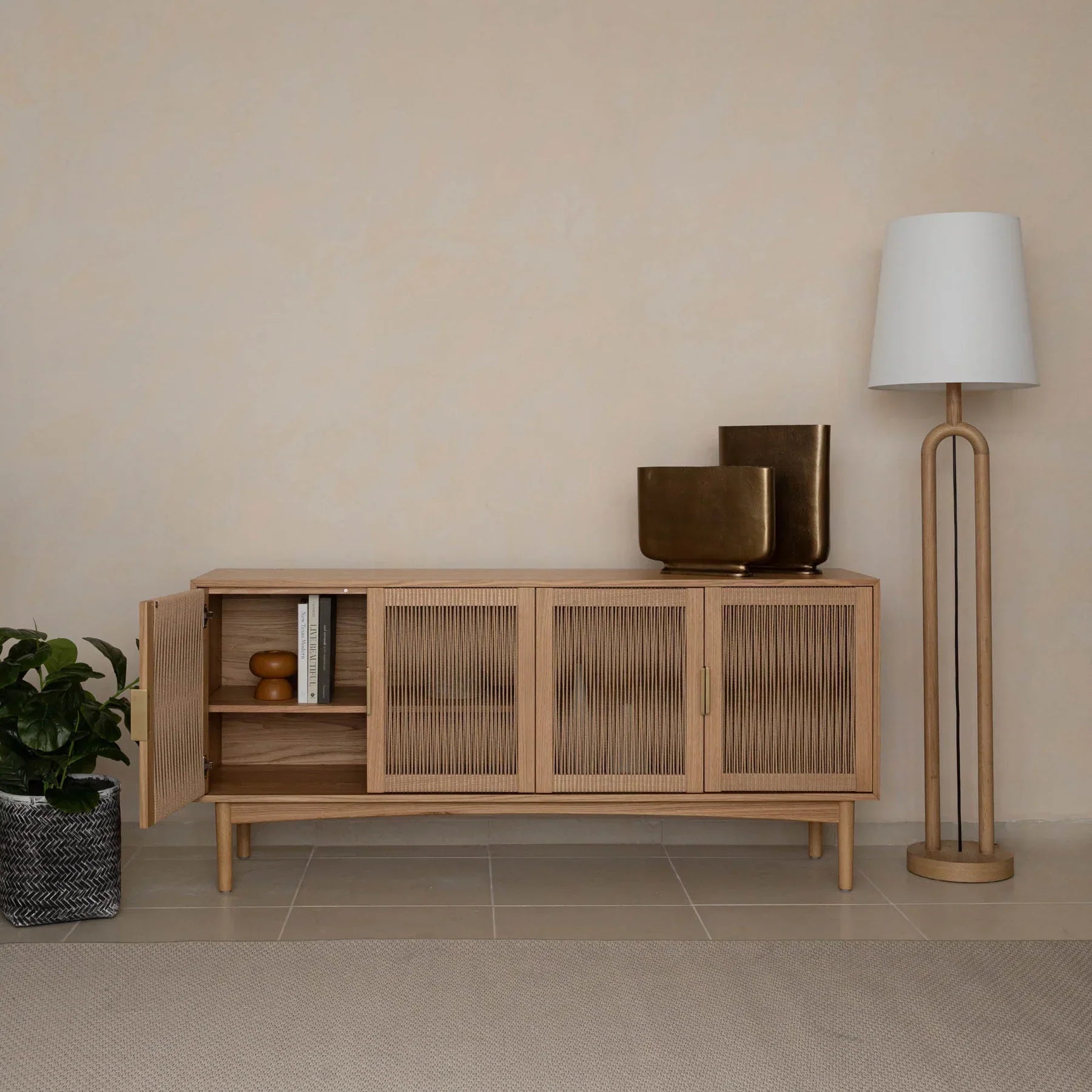 Front perspective view of the Lumina 4-door sideboard featuring a light oak wood frame, fluted glass door panels, and elegant vertical gold metal handles