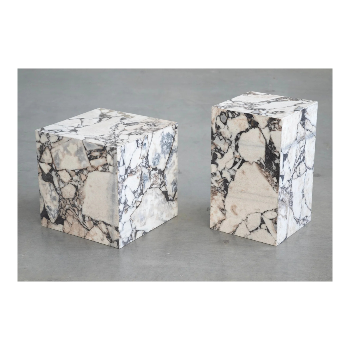 Perspective shot of two Calacatta Viola marble plinths in different heights showcasing the natural stone patterns and polished block silhouette