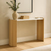 Lifestyle shot of the white marble and oak console table styled with a ceramic vase and books in a bright modern entryway