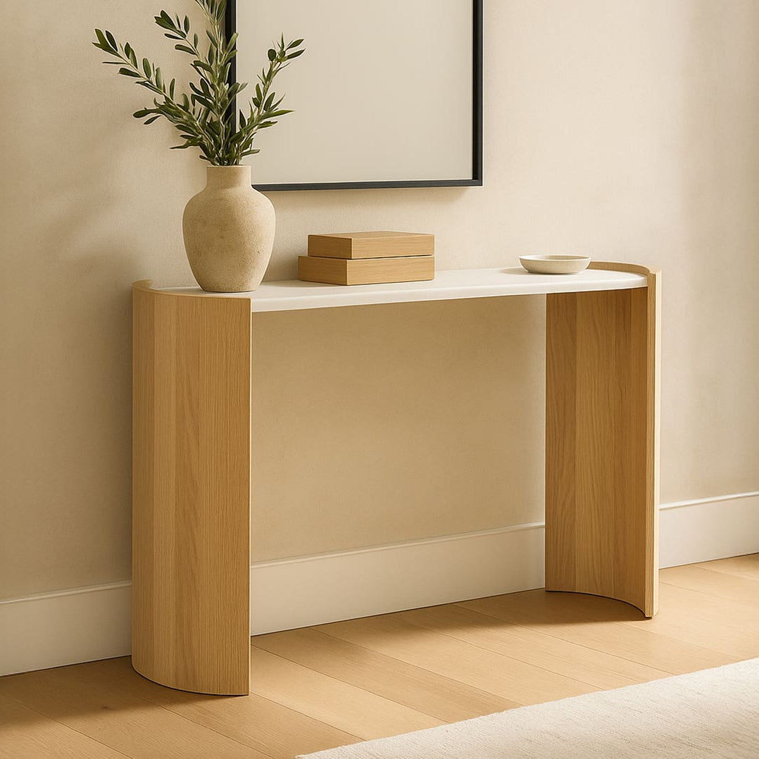 Lifestyle shot of the white marble and oak console table styled with a ceramic vase and books in a bright modern entryway