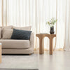 Three-quarter perspective view highlighting the thick structural legs and smooth curved cutouts of the architectural wood table