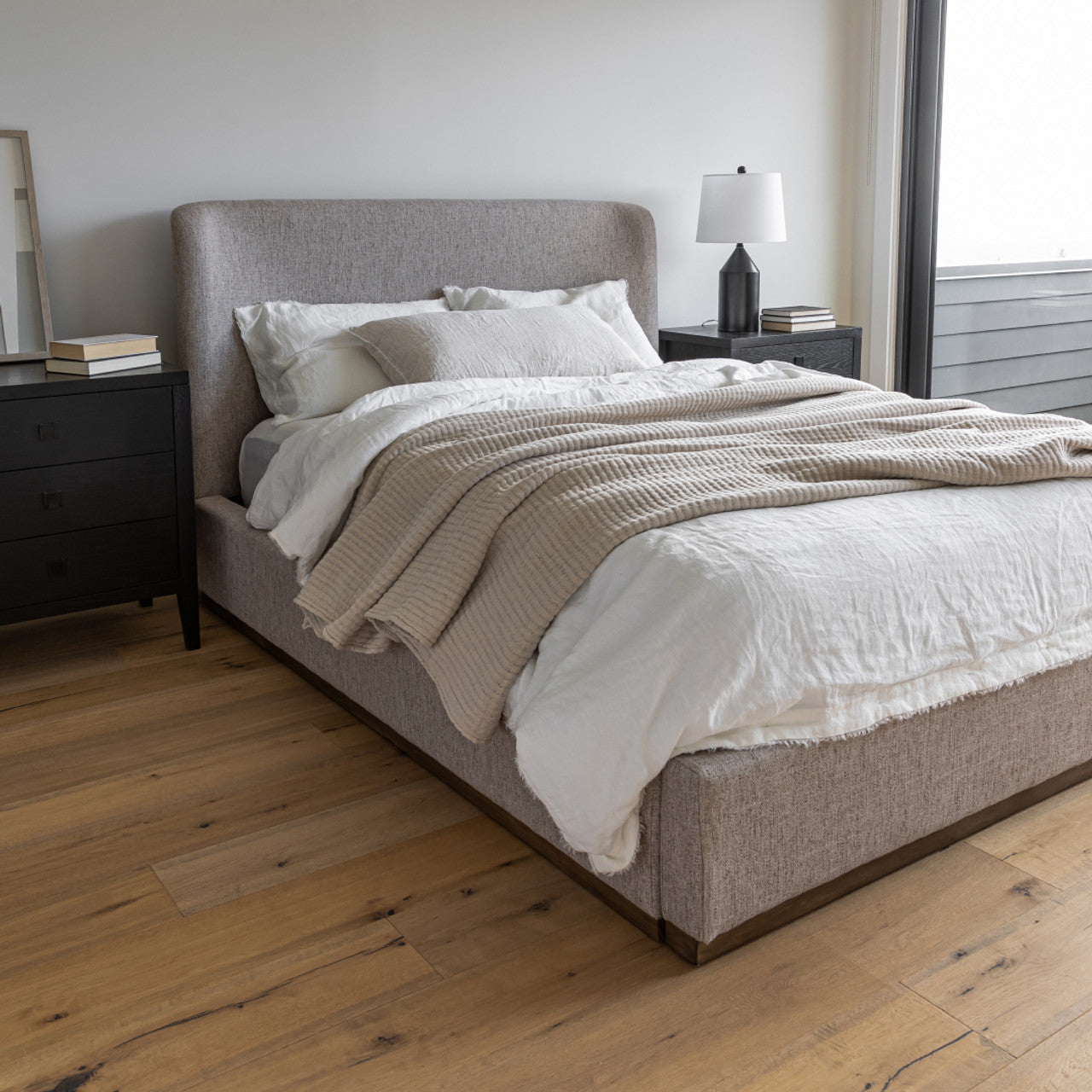 Front view of the Faye platform bed featuring a curved wingback headboard and textured taupe fabric upholstery