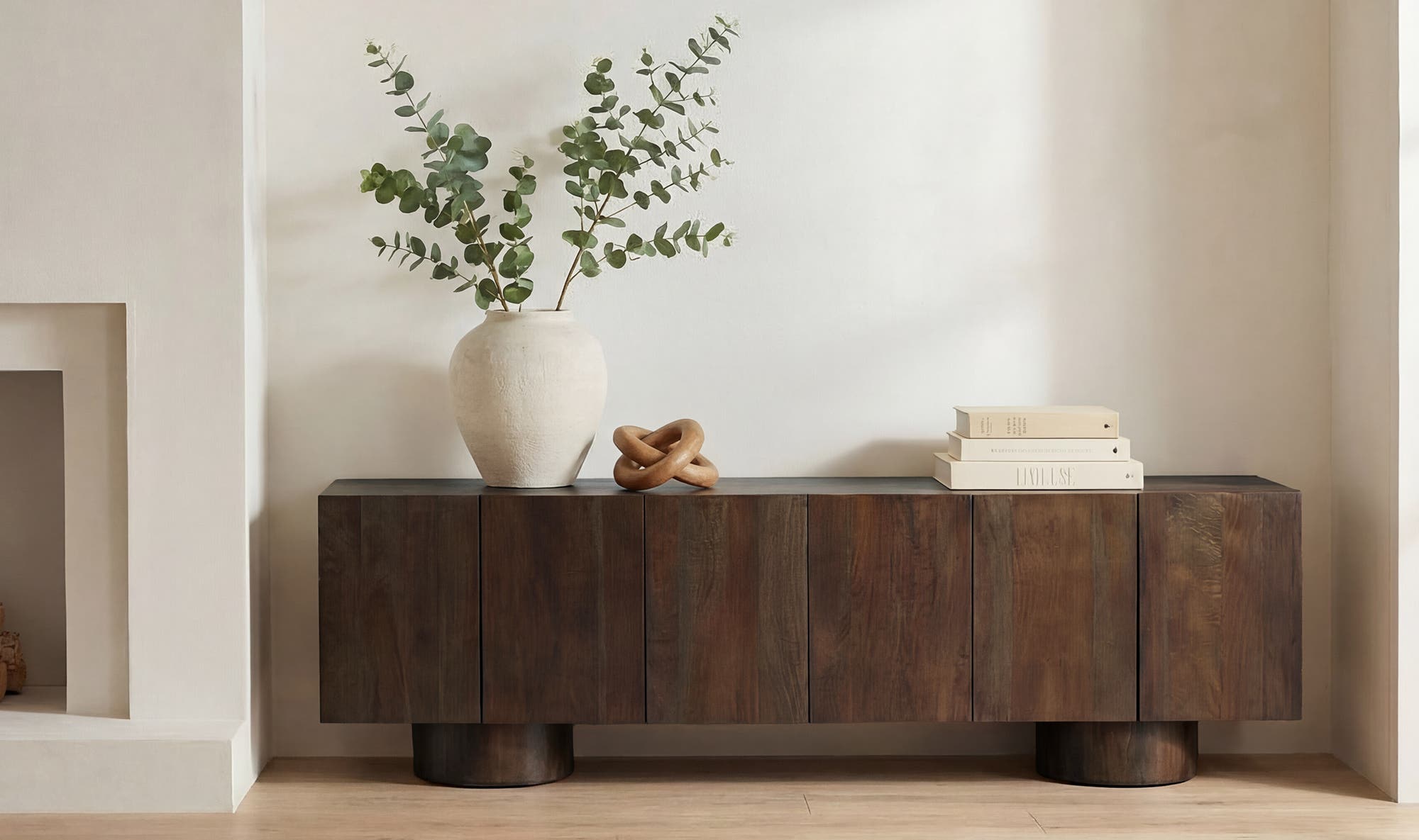 Lifestyle shot featuring the Hadley media unit styled with minimalist ceramics and greenery in a bright contemporary home setting