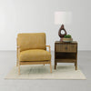 Studio lifestyle shot featuring the nightstand alongside a yellow accent chair highlighting its versatility in different room settings