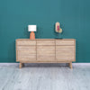 Lifestyle shot of the Gia sideboard styled with a minimalist table lamp and contemporary decor against a deep teal wall