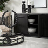 Close-up lifestyle shot of the sideboard interior and top surface styled with bowls and monochrome decor