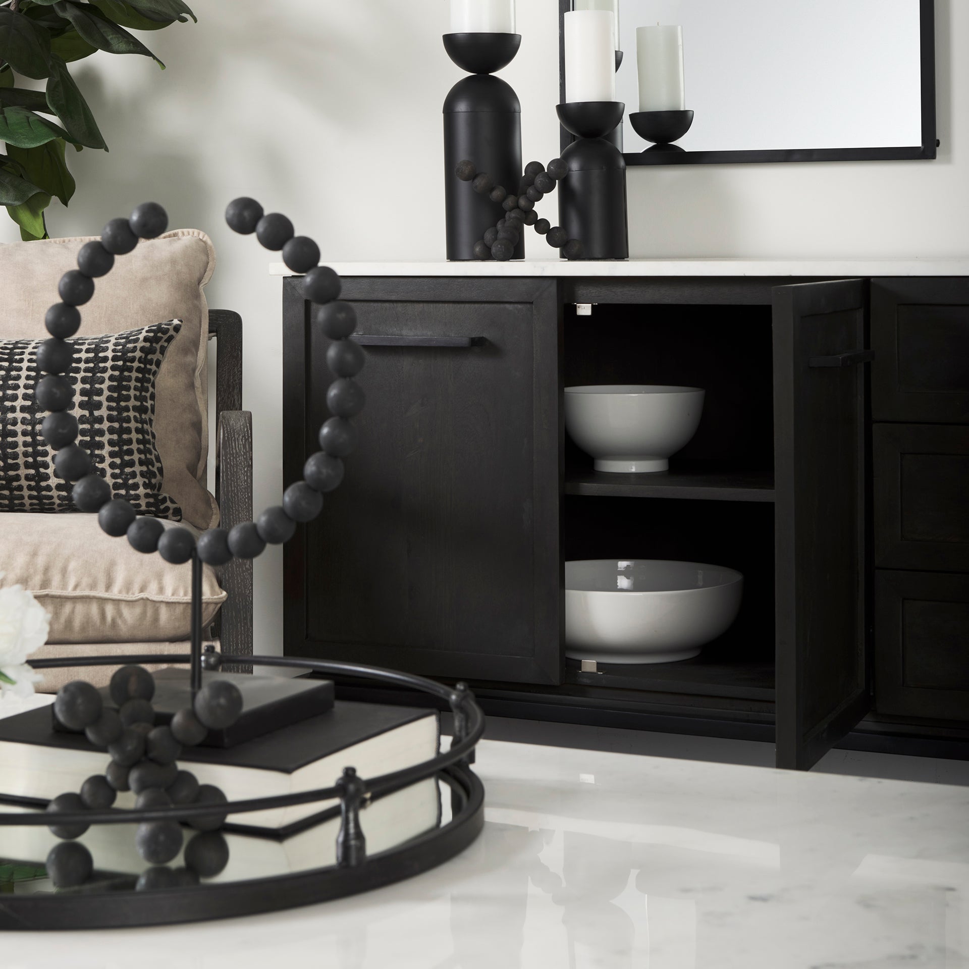 Front perspective view of the Gemma sideboard featuring a dark charcoal wood finish, a white marble top, and slim black metal legs