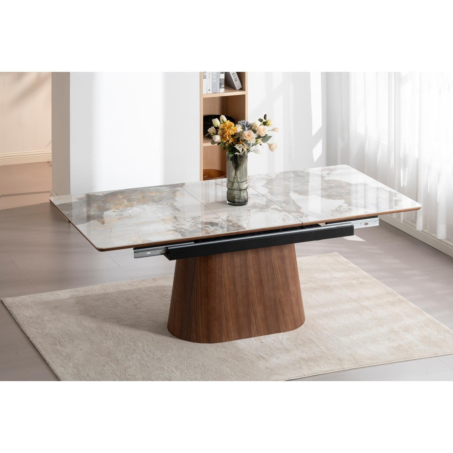Front view of the Hyld extendable dining table featuring a white patterned ceramic top and a substantial walnut-finished wood pedestal base