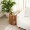 Lifestyle shot of the natural wood side table styled in a bright minimalist room next to a white upholstered sofa