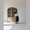 Action shot showing the smooth sliding functionality of the lower rattan cabinet doors
