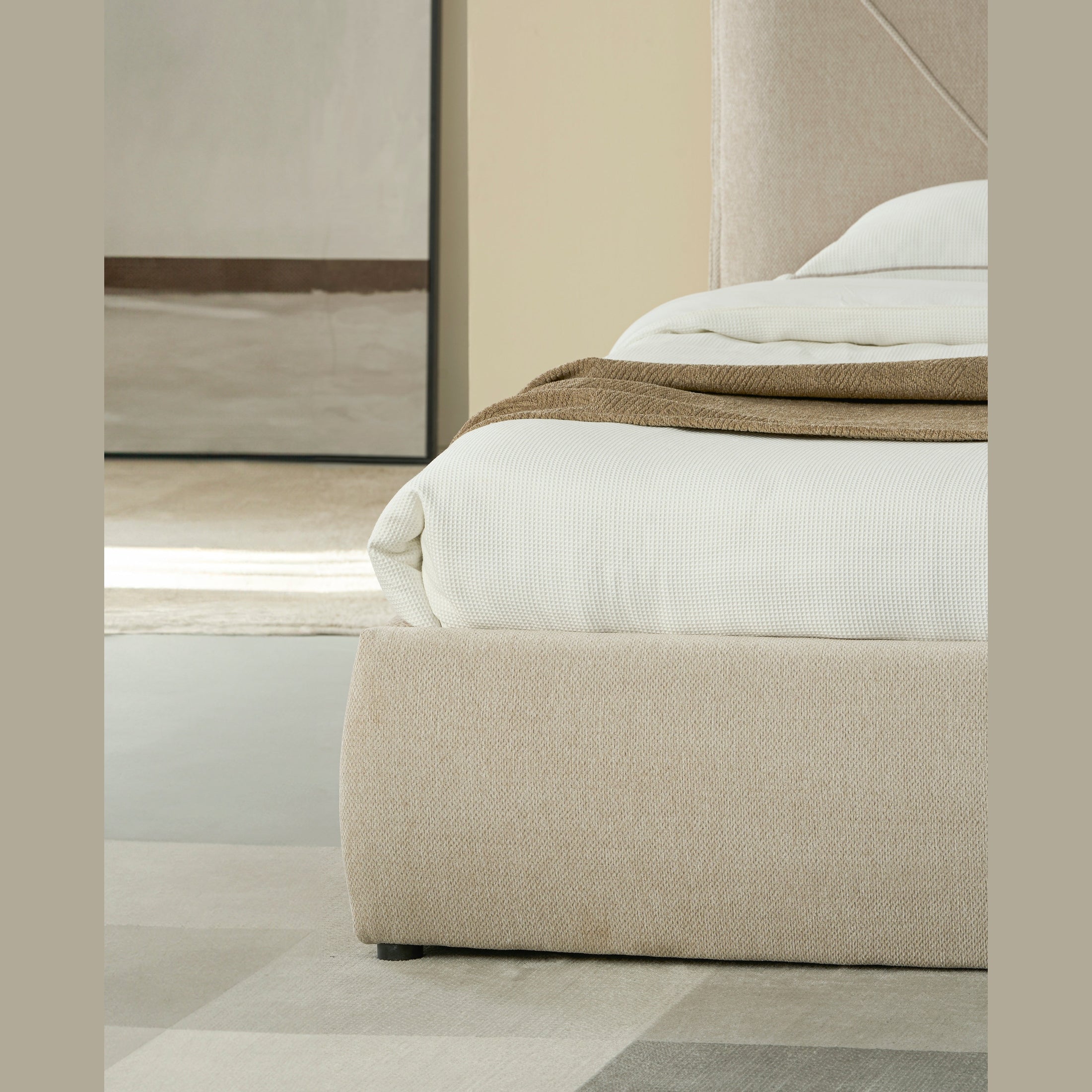 Front view of the Aici storage bed featuring a cream fabric finish and a unique V-shaped geometric stitched headboard