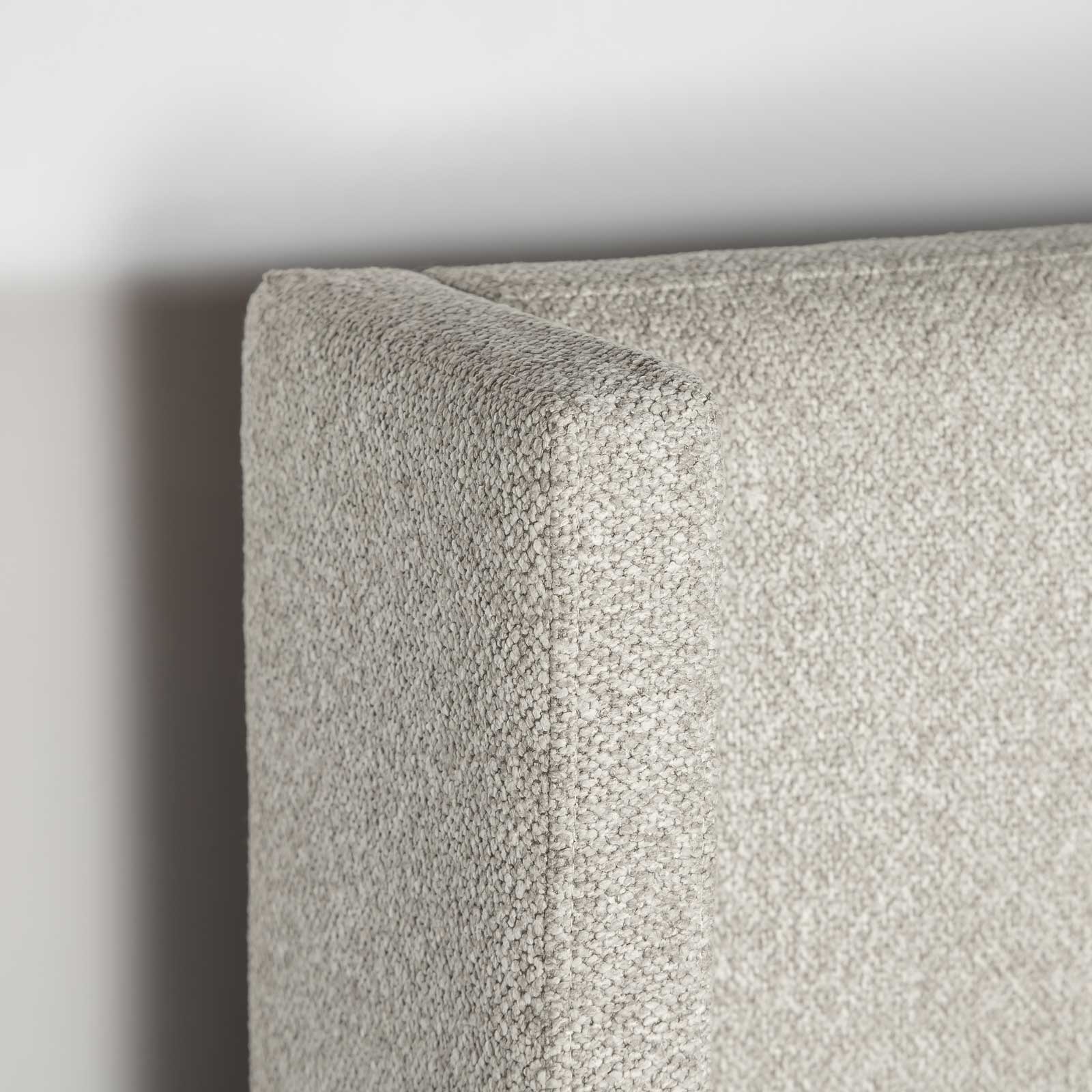Perspective detail shot focusing on the rounded corner of the platform base and the rich tactile dune fabric