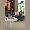 Close-up side perspective view emphasizing the sculptural and grounding presence of the white pedestal table