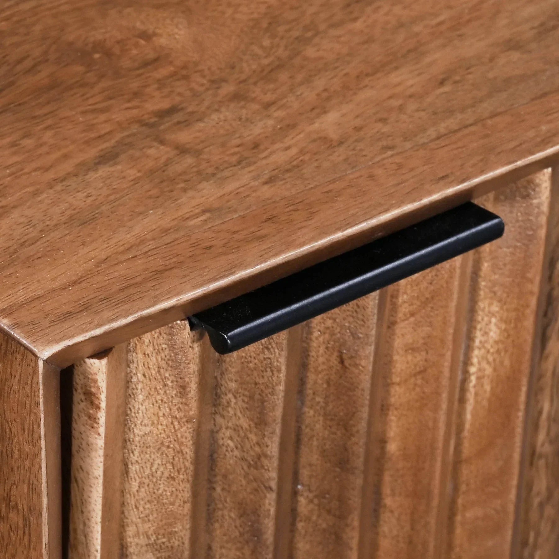 Front view of the Nikita nightstand featuring a geometric hand-carved wood door design and a minimalist black metal frame base