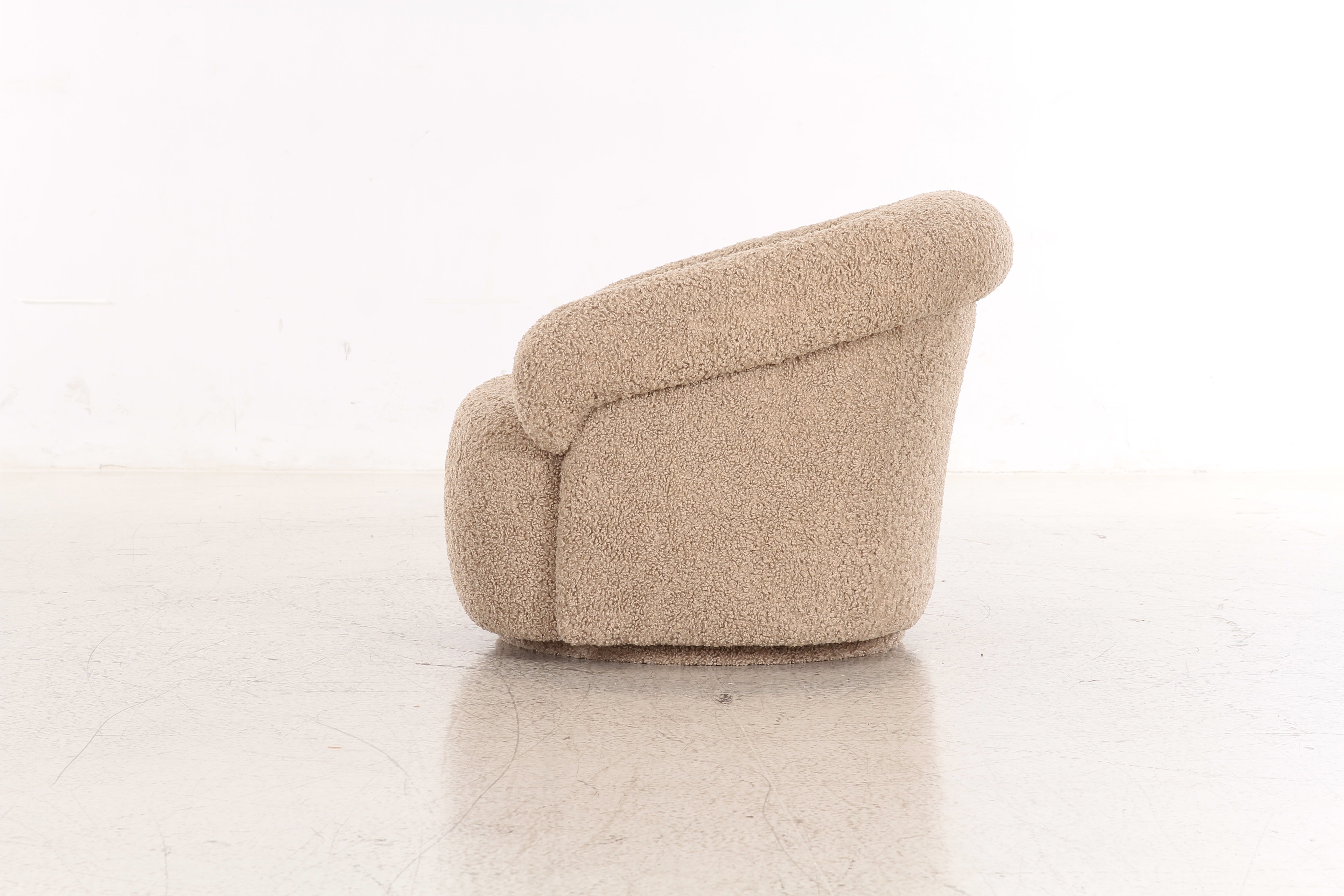 Front view of the Mollis swivel accent chair in beige bouclé featuring a rounded sculptural silhouette and plush integrated armrests