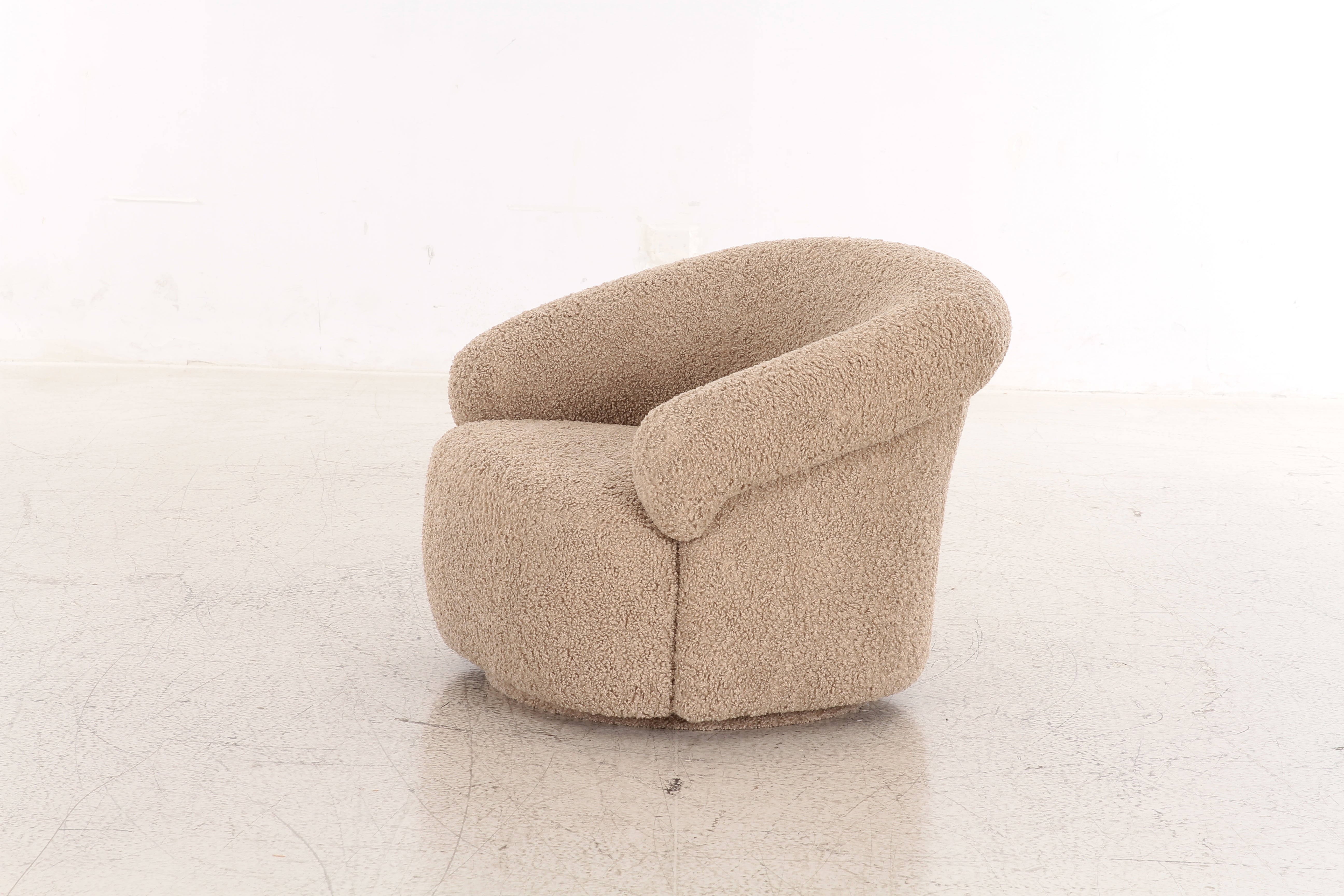 Front view of the Mollis swivel accent chair in beige bouclé featuring a rounded sculptural silhouette and plush integrated armrests