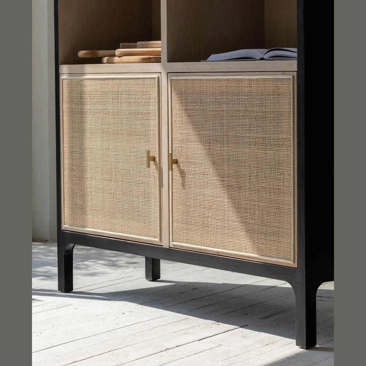 Straight-on front view showcasing the symmetrical six-compartment open shelving and lower cane-front storage