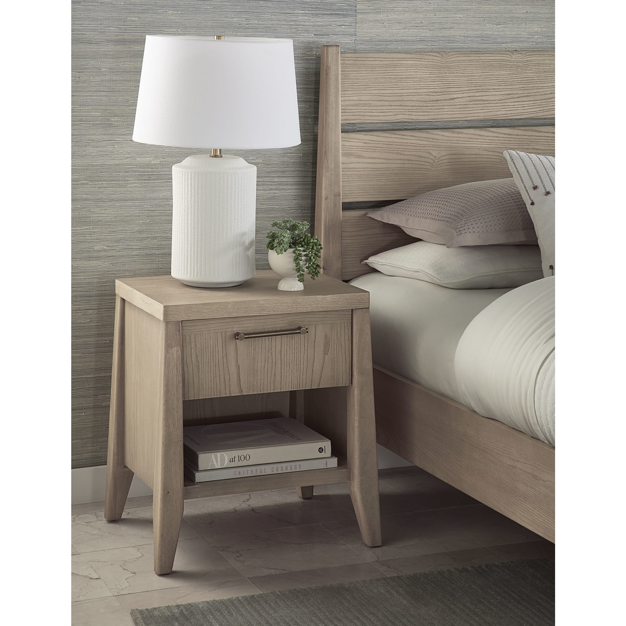 Front view of the Nettie nightstand featuring a warm ginger ash wood finish, a single drawer, and a lower open storage shelf