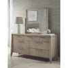 Studio lifestyle shot featuring the Nettie dresser and mirror styled with a modern lamp and vase against a textured gray wall