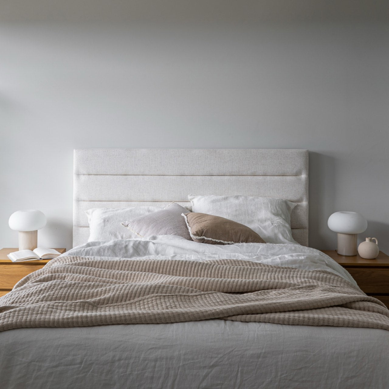 Front view of the Julia storage bed featuring a soft sand fabric and a modern horizontal channel tufted headboard