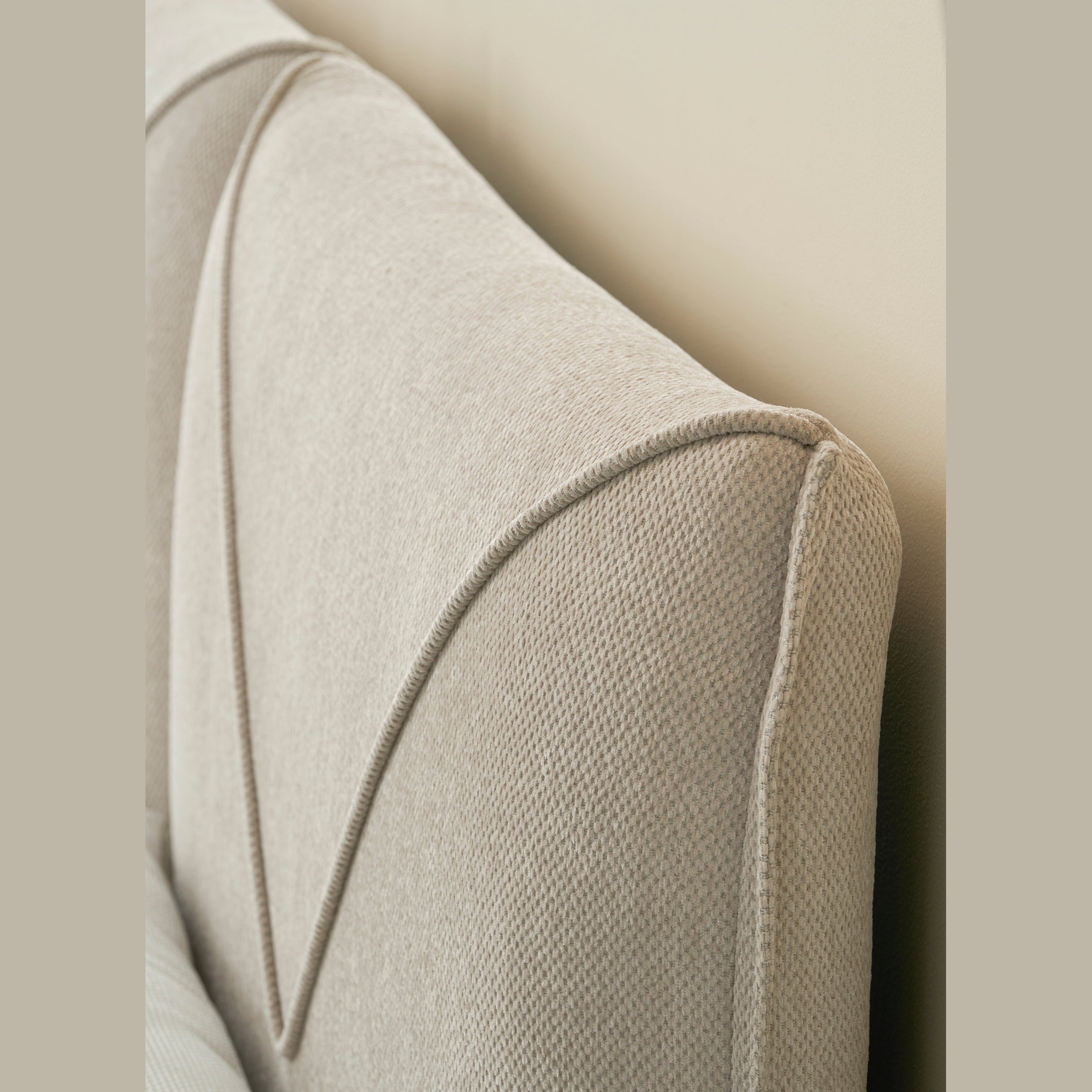 Front view of the Aici storage bed featuring a cream fabric finish and a unique V-shaped geometric stitched headboard