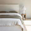 Lifestyle view focusing on the tonal harmony between the cream bed and the surrounding neutral decor