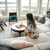 Side-angle lifestyle view of a person relaxing by the Nila marble table in a modern living space