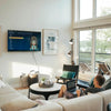 Lifestyle perspective of the Nila table in a light-filled room with floor-to-ceiling windows and lake views