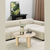 Angled lifestyle perspective highlighting how the cream stone table complements a soft neutral color palette