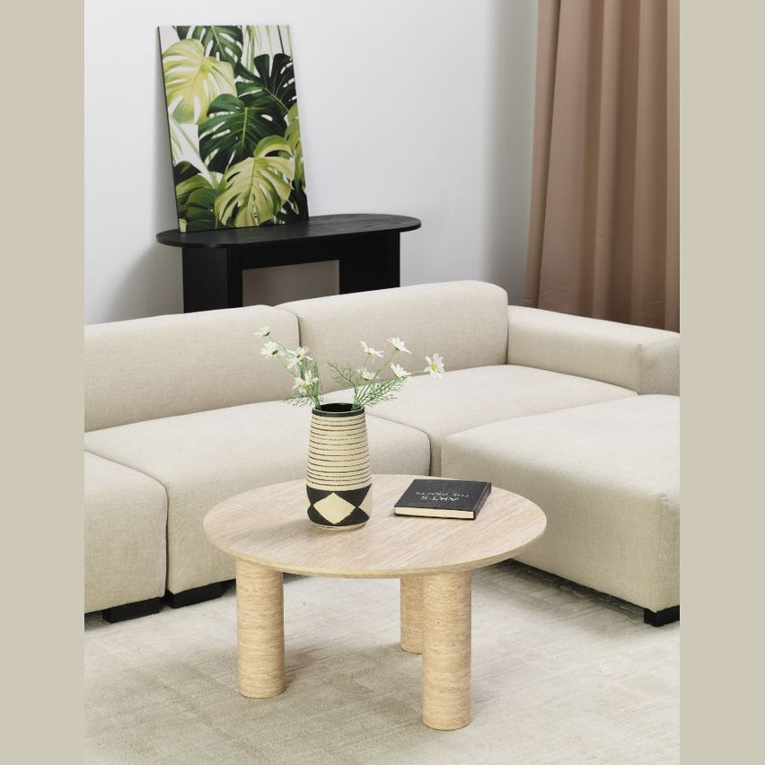 Angled lifestyle perspective highlighting how the cream stone table complements a soft neutral color palette